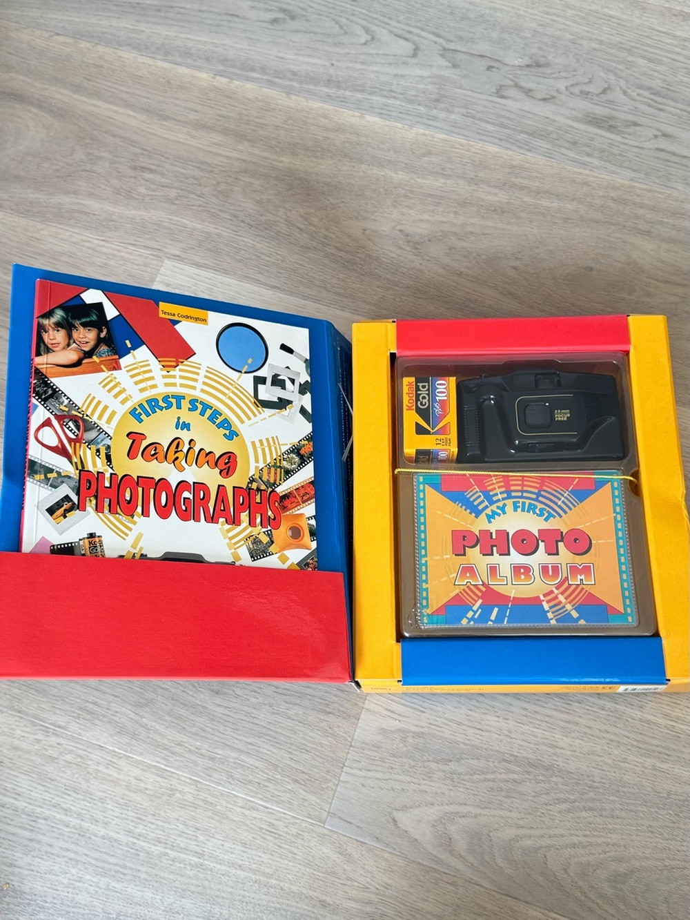 Vintage photo kit with a 35mm disposable camera, film roll and an album